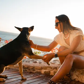 High five with a dog above the ocean at golden hour on the SYB Nicaragua Surf Camp trip