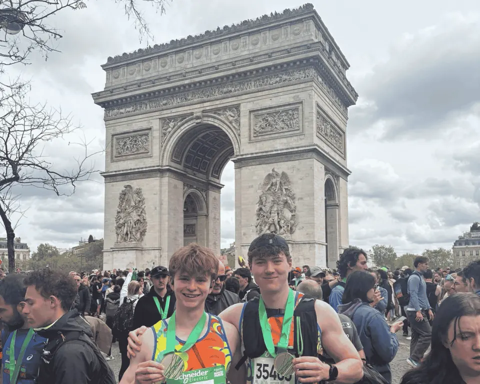 Two Hardest Adventures Paris Marathon finishers posing in front of the Arc de Triomphe.