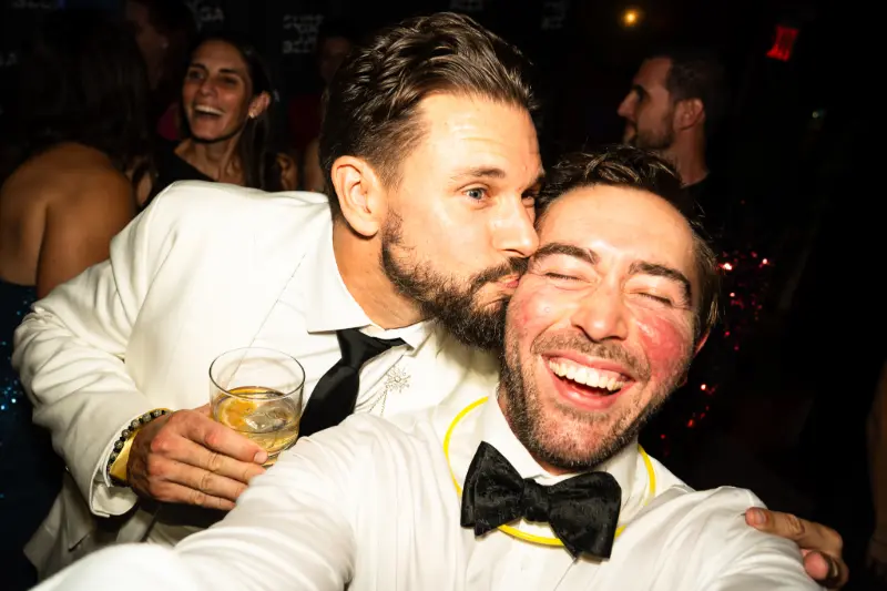 Two friends in tuxedos taking a selfie