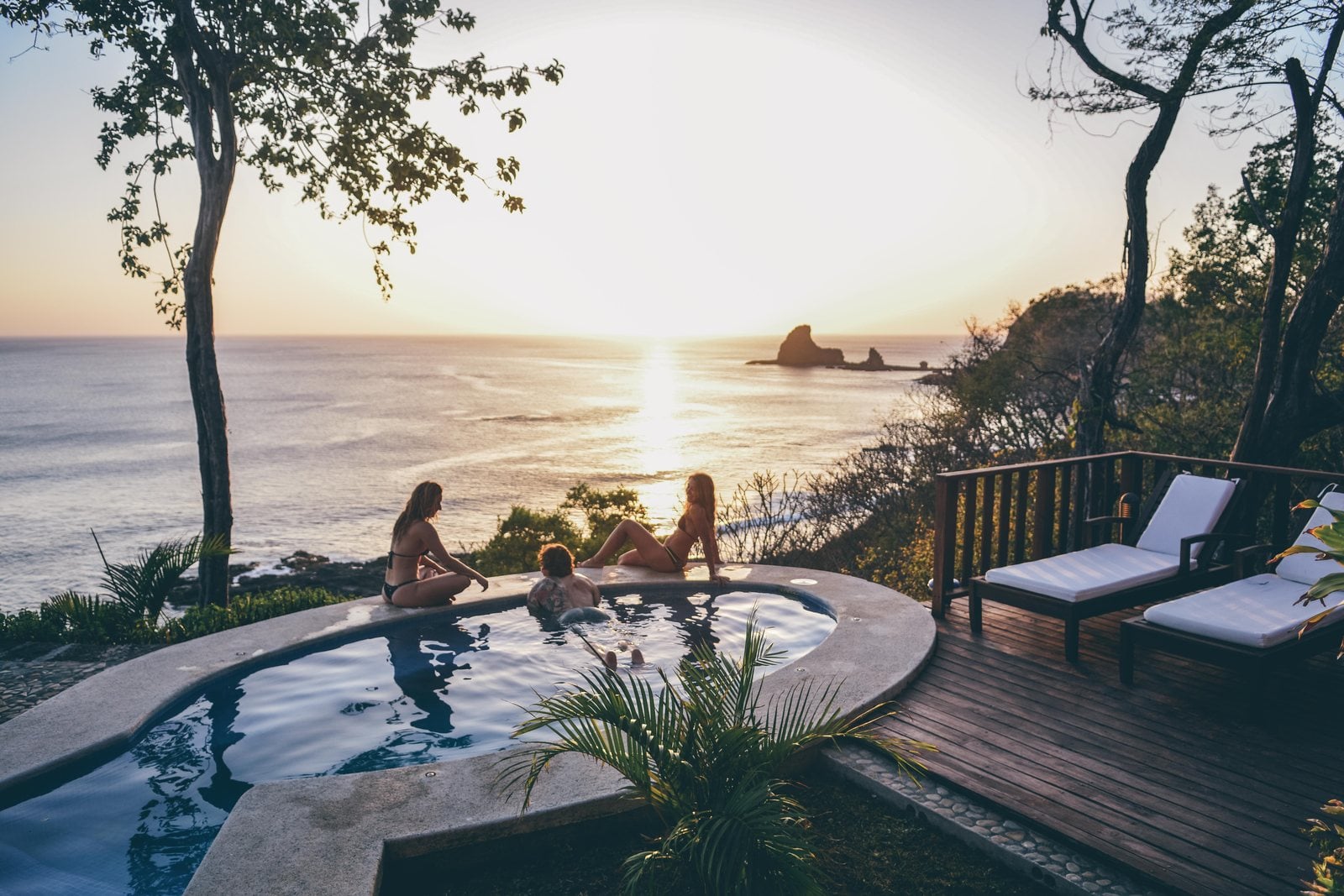 Friends in a plunge pool at sunset