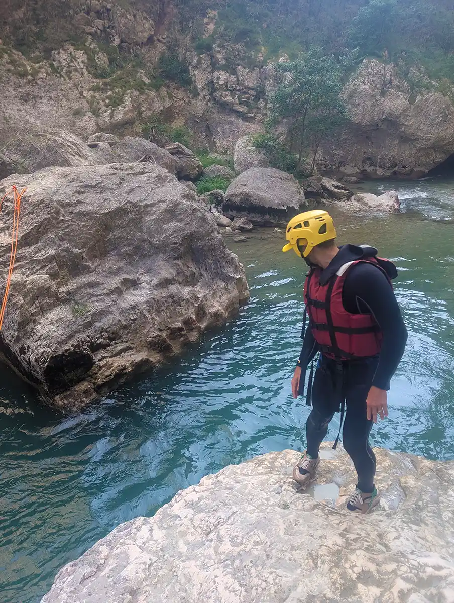 SurfYogaBeer guest in a helmet and wetsuit on the aqua rando day in the Verdon Gorge