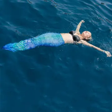Swimming in a mermaid tail in deep blue water on the SYB Greece trip