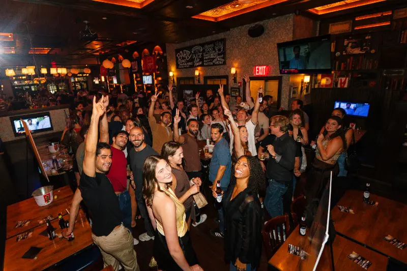 Crowd cheering with arms up at the SYB pre-gala party