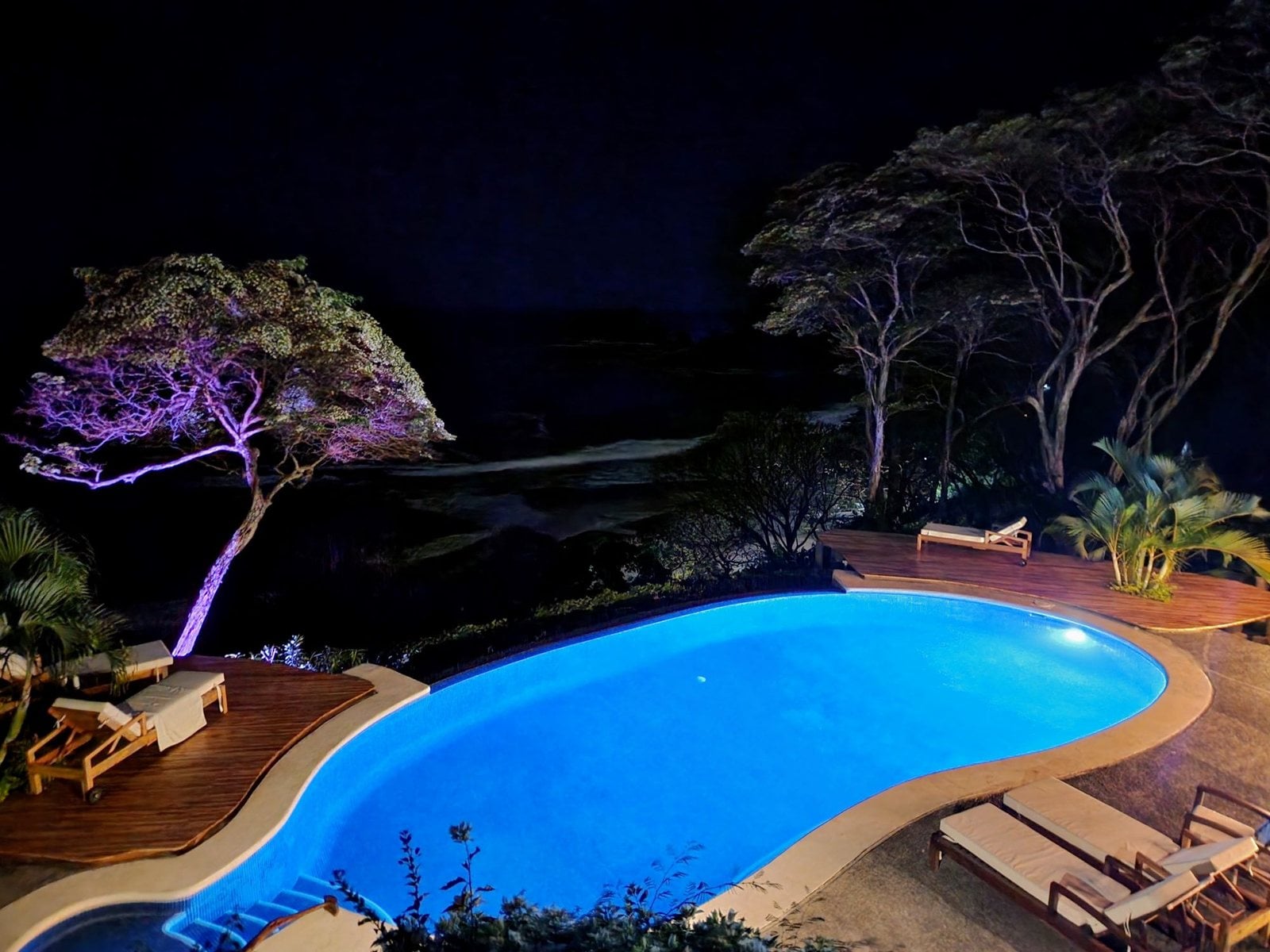 A villa pool lit up at night