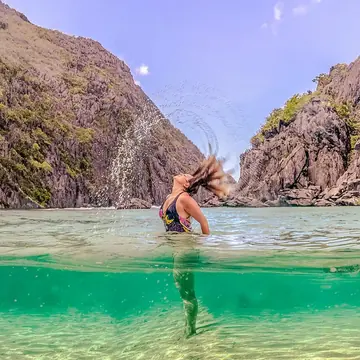 Hair flip in a turquoise lagoon between limestone cliffs on the SYB Philippines trip