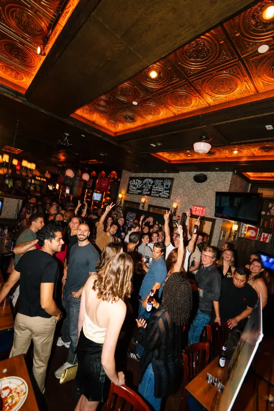 Packed bar with hands in the air