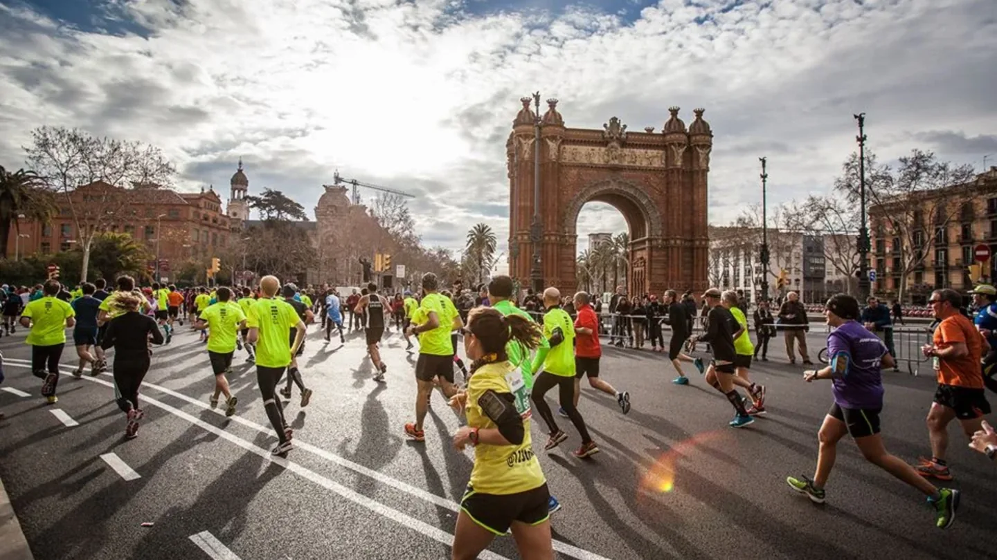 Barcelona Marathon runners approaching the Arc de Triomf on race day.