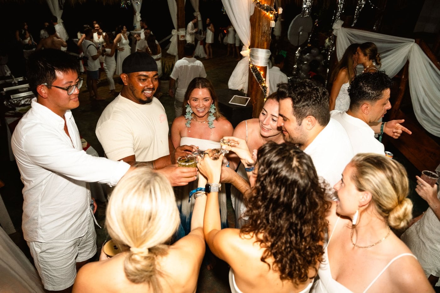SurfYogaBeer group in all white raising a toast on New Year in Nicaragua