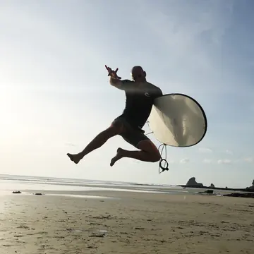 Jumping in the air with a surfboard on the beach on the SYB Nicaragua trip