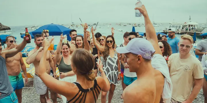 The crew cheering with drinks on the beach on the SYB Amalfi Coast trip