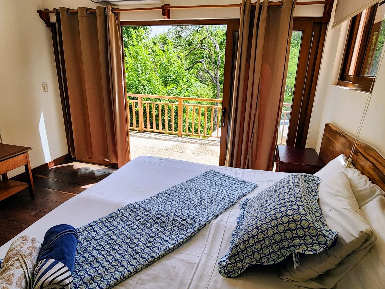 A bedroom opening onto a jungle deck