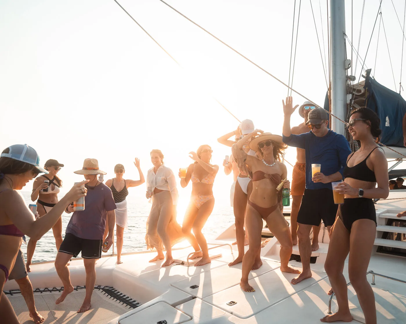SYB travelers dancing on the deck of a catamaran at golden hour off the coast of Nicaragua