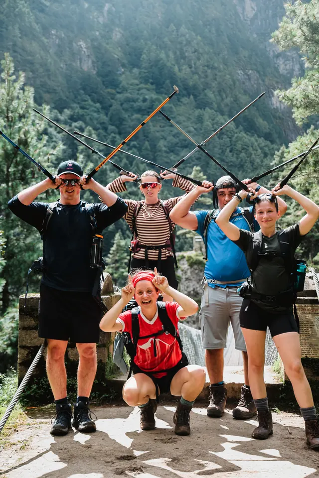 Hardest Adventures trekkers posing with their poles on the Hillary suspension bridge above the Dudh Koshi