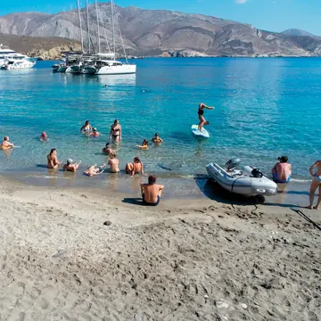 Swimming off a quiet beach with the catamarans anchored in the bay on the SYB Greece trip