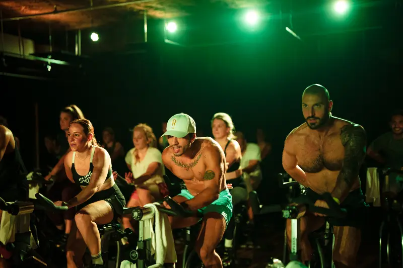 Riders under green lights in the cycling class