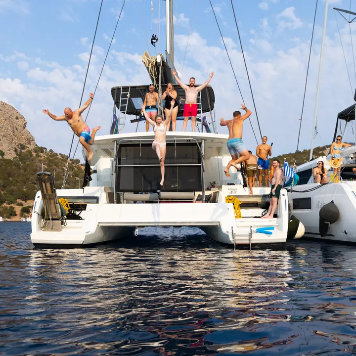 Friends leaping off the top of a catamaran into the sea on the SYB Greece trip
