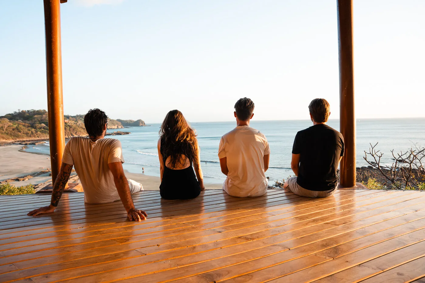 Four travelers sitting on a deck looking out at the Pacific in Nicaragua