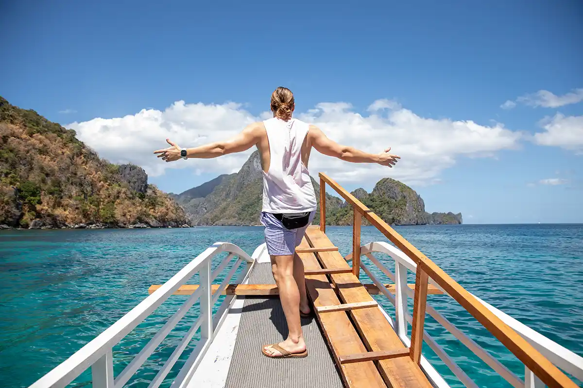 SurfYogaBeer guest jumping off the paraw boat into turquoise water