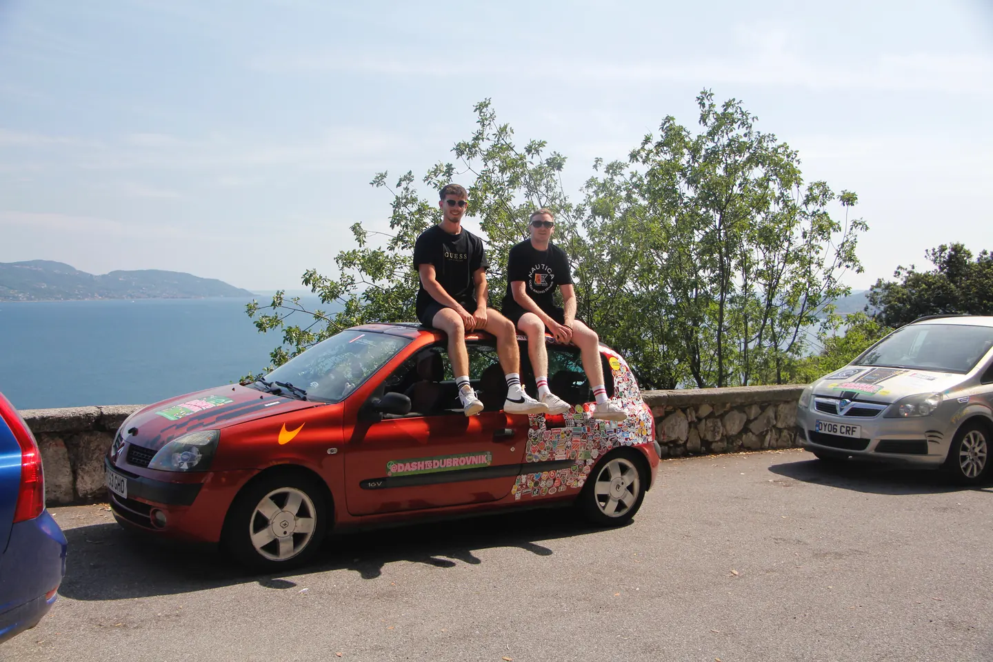 Hardest Adventures crew sitting on their car roof during a stop on the Dash to Dubrovnik rally.