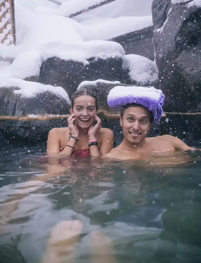 SurfYogaBeer guests in an outdoor onsen in the snow