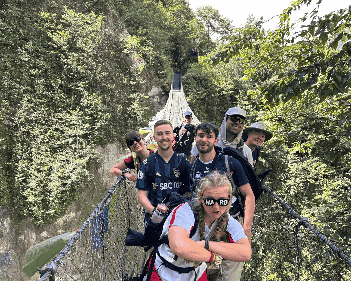 Group of hikers laughing on a bridge during the everest base camp trek.