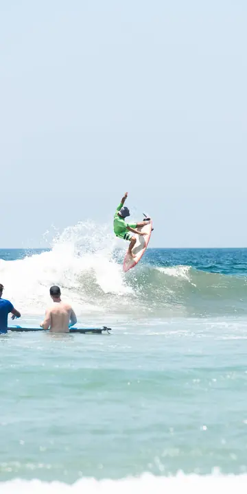 Surfer hitting the top of a breaking wave on the SYB Nicaragua Surf Camp trip