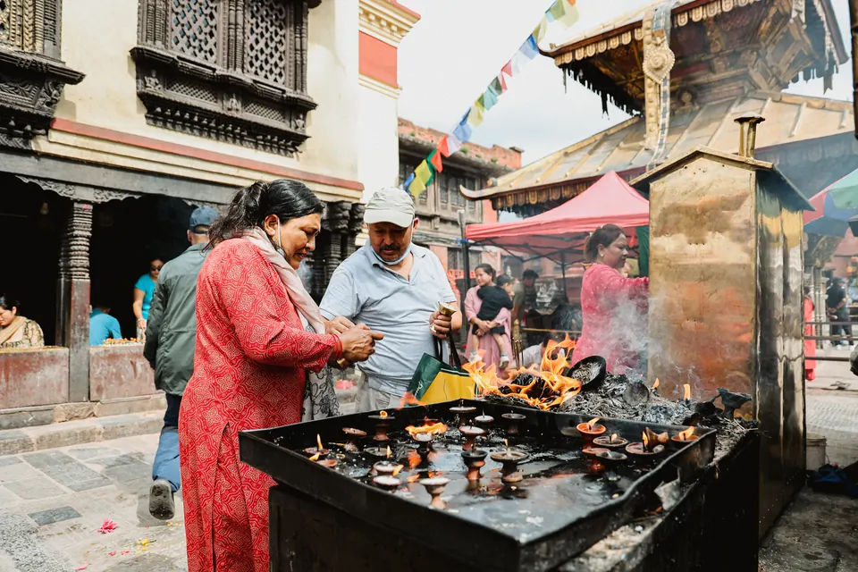 Butter lamps burning at a shrine below the Swayambhunath stupa, Kathmandu