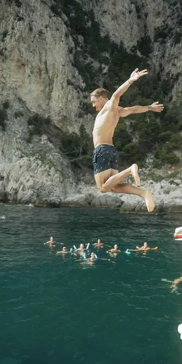 Leaping off the boat toward the swimmers below the cliffs on the SYB Amalfi Coast trip
