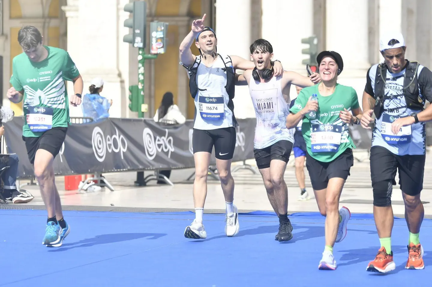 Runner celebrating with elation at the Lisbon Marathon finish line with Hardest Adventures.