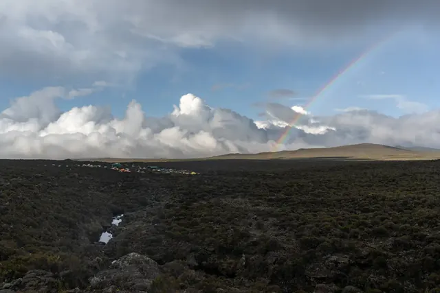 Rainbow arcing over the moorland zone on Mount Kilimanjaro during a Hardest Adventures trek.