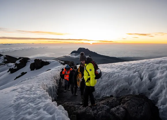 Hikers descending from Uhuru Peak on their low-cost Hardest Adventures Mount Kilimanjaro trek.