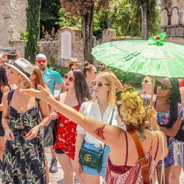 The group walking through town under a green parasol on the SYB Amalfi Coast trip