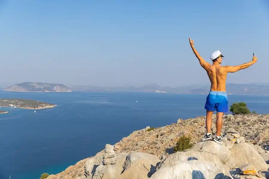 A guest celebrating on a hilltop above the sea