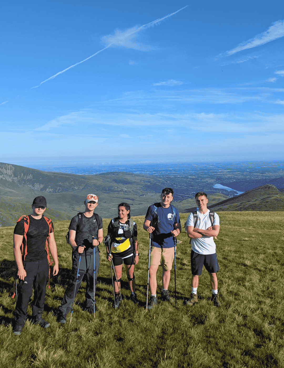 Group of hikers completing the UK national three peaks charity challenge with Hardest Adventures on a clear sunny day.
