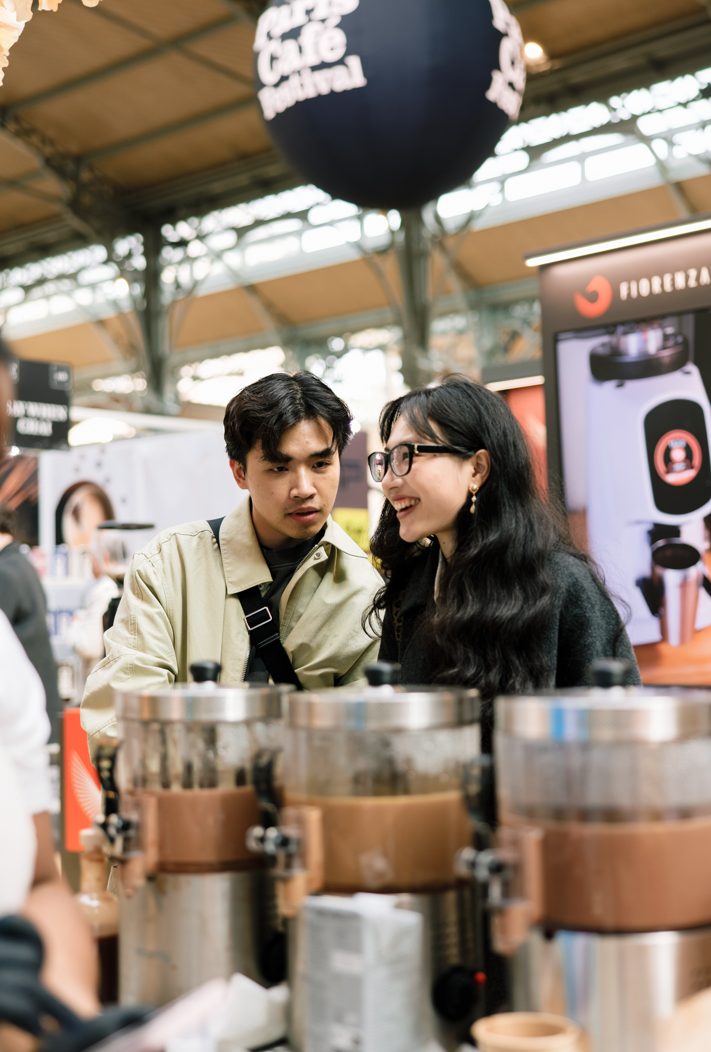 Deux visiteurs d&eacute;couvrent les caf&eacute;s pr&eacute;sent&eacute;s sur un stand du festival