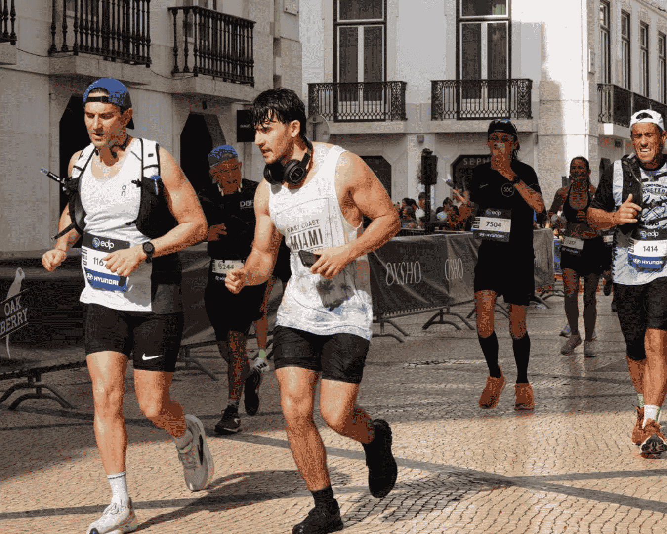 Two runners holding each other up as they push to finish the Athens marathon with Hardest Adventures.