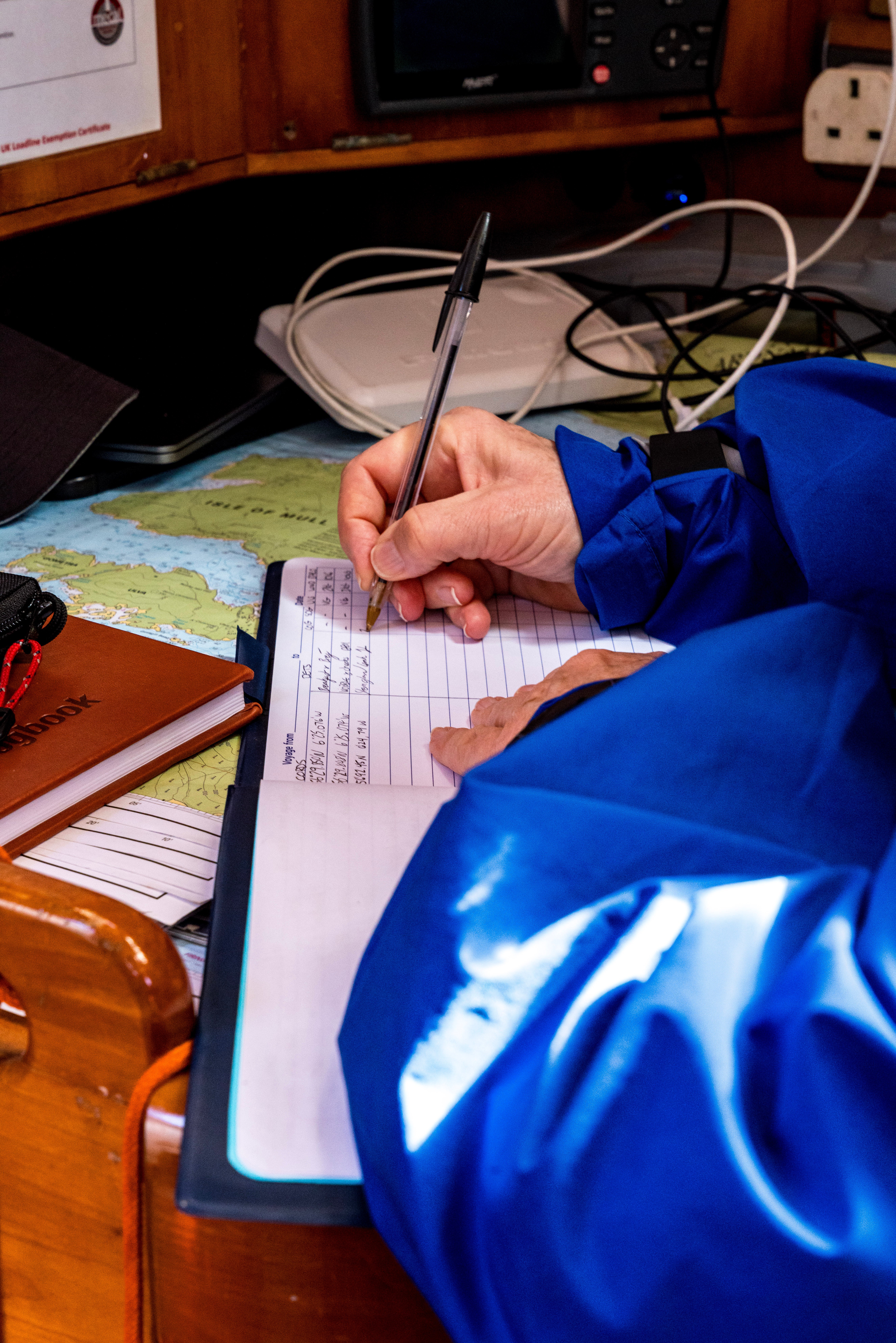 A Wavysail crew member completing a log entry