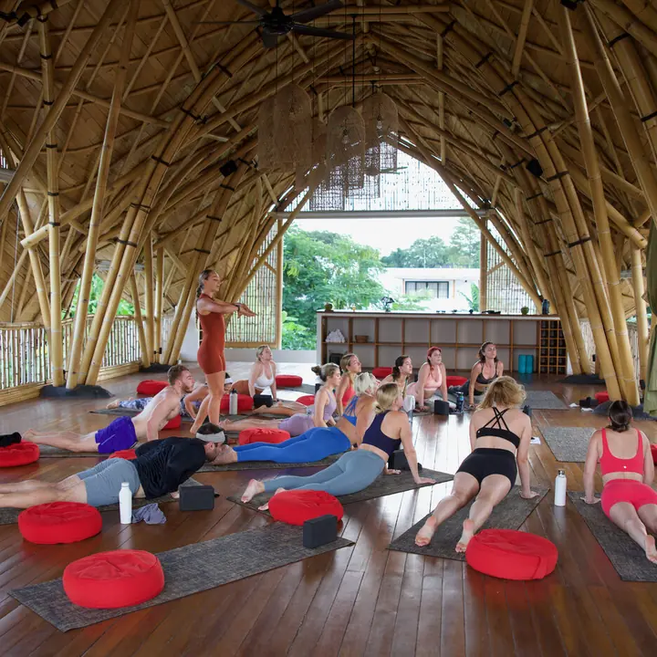 Group yoga class under a soaring bamboo roof on the SYB Bali trip