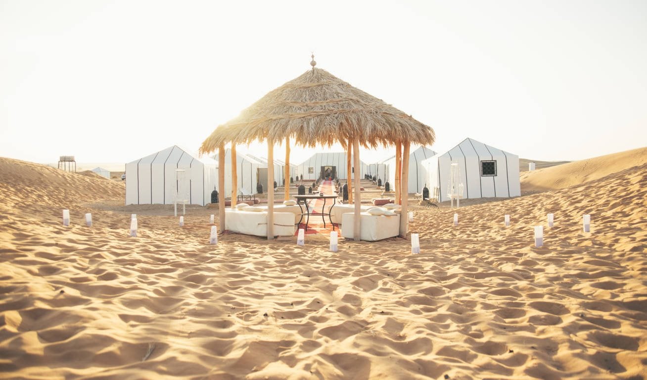 Shaded lounge out on the sand at Sahara Desert Luxury Camp