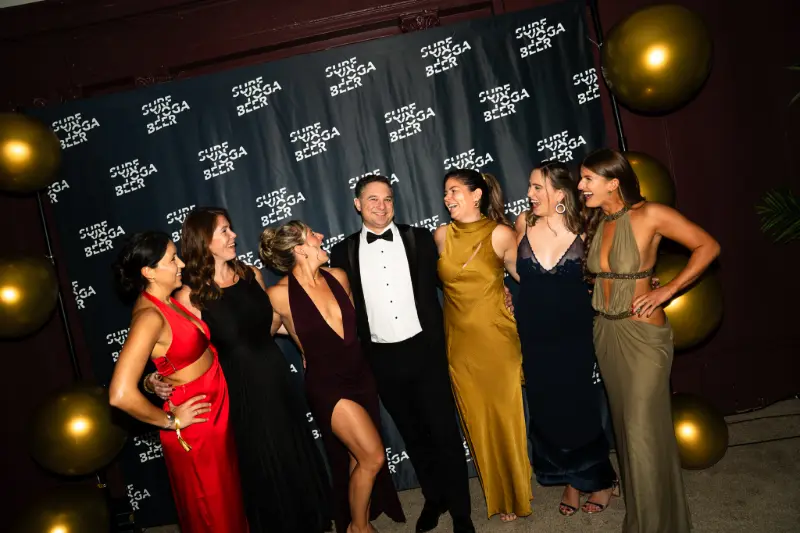 Friends in gowns and a tux at the photo wall