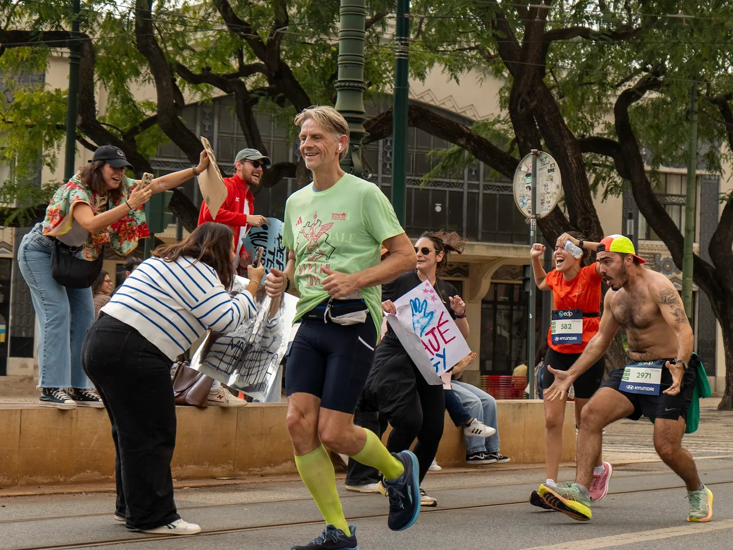 Runner high-fiving the crowd during the Lisbon Marathon with Hardest Adventures.