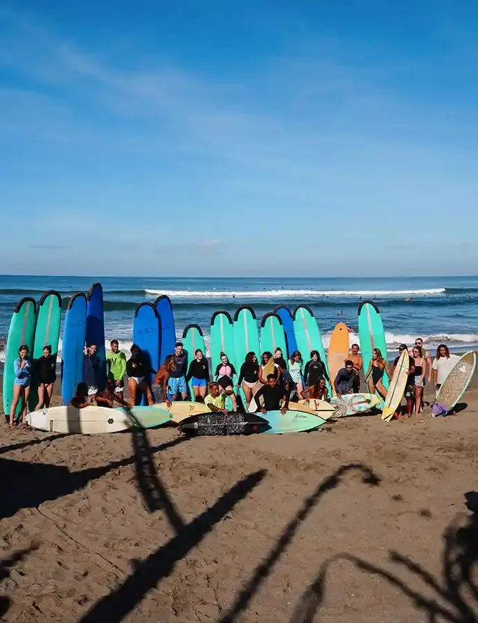 A row of surfboards and an SYB group on the beach in Canggu, Bali