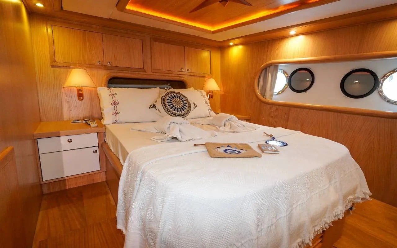 A double cabin with one queen bed, wood panelling and porthole windows