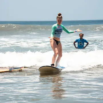 Standing up on a first wave during a surf lesson