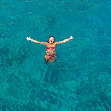 Floating on her back in clear turquoise water on the SYB Turkey trip