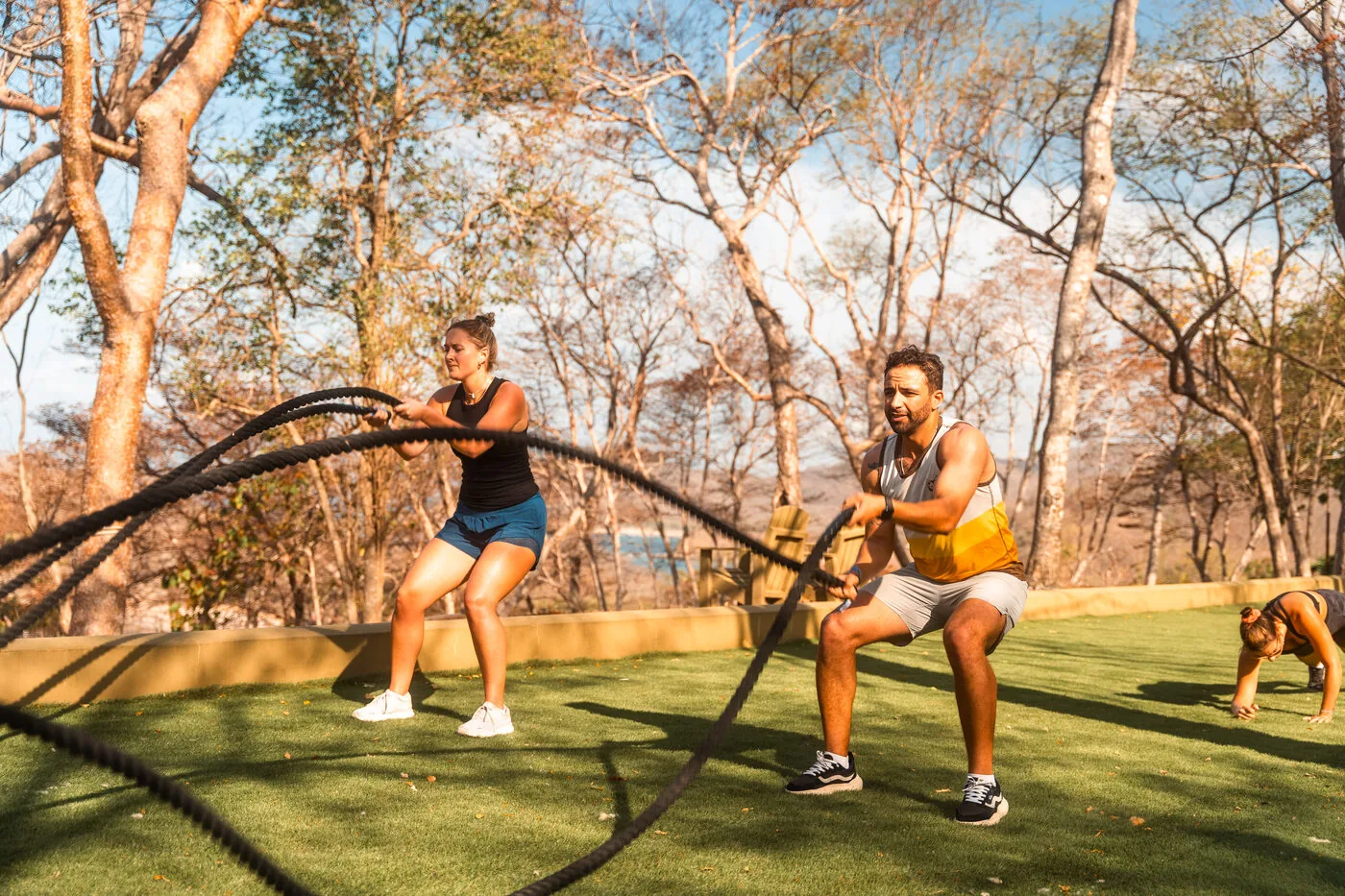Two travelers training with battle ropes on the lawn at the villas in Nicaragua