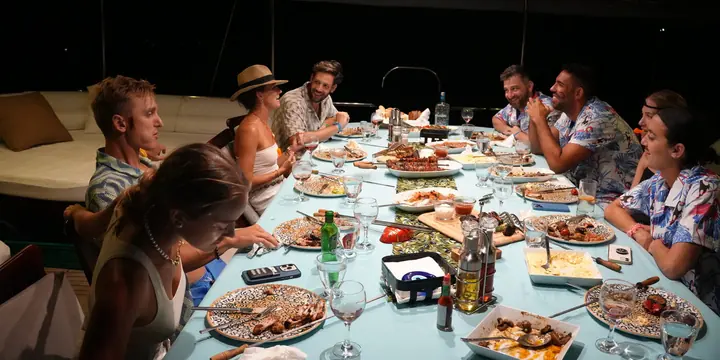 Crew sharing a big dinner around the table on board at night on the SYB Turkey trip