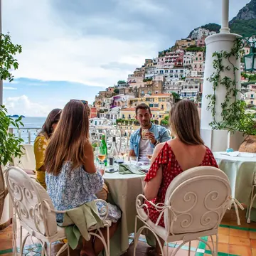 Lunch on a terrace looking out at a cliffside town on the SYB Amalfi Coast trip