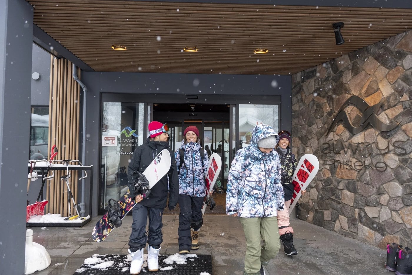 Snowboarders heading out the front doors of Always Niseko