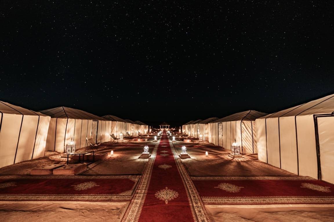 Lantern-lit tents at Sahara Desert Luxury Camp at night
